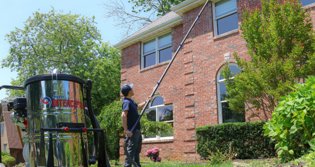 sparkle squad technician cleaning gutters of a residential home